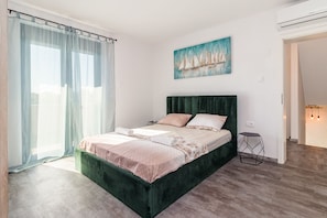 Una camera da letto moderna con un letto grande, un comodino e un quadro appeso al muro.