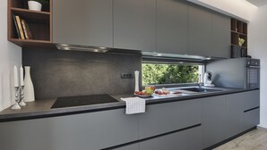 A modern kitchen with grey cabinets, a black countertop, and a built-in oven. - 700 metres to the beach with private pool, WiFi, sea view (Medulin)