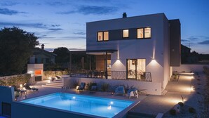 A modern two-story house with a swimming pool, outdoor seating, and a well-lit patio area. - 700 metres to the beach with private pool, WiFi, sea view (Medulin)
