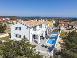 A modern two-story house with a swimming pool, surrounded by a well-maintained lawn and trees. - 500 metres to the beach with private pool, sea view, wifi (Liznjan)