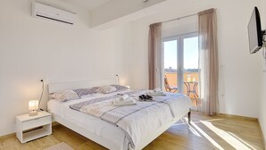 A bedroom with a bed, bedside table, lamp, air conditioning unit, and a view of the outside. - Villa with private pool, playground, WiFi, air conditioning, BBQ (Pula)