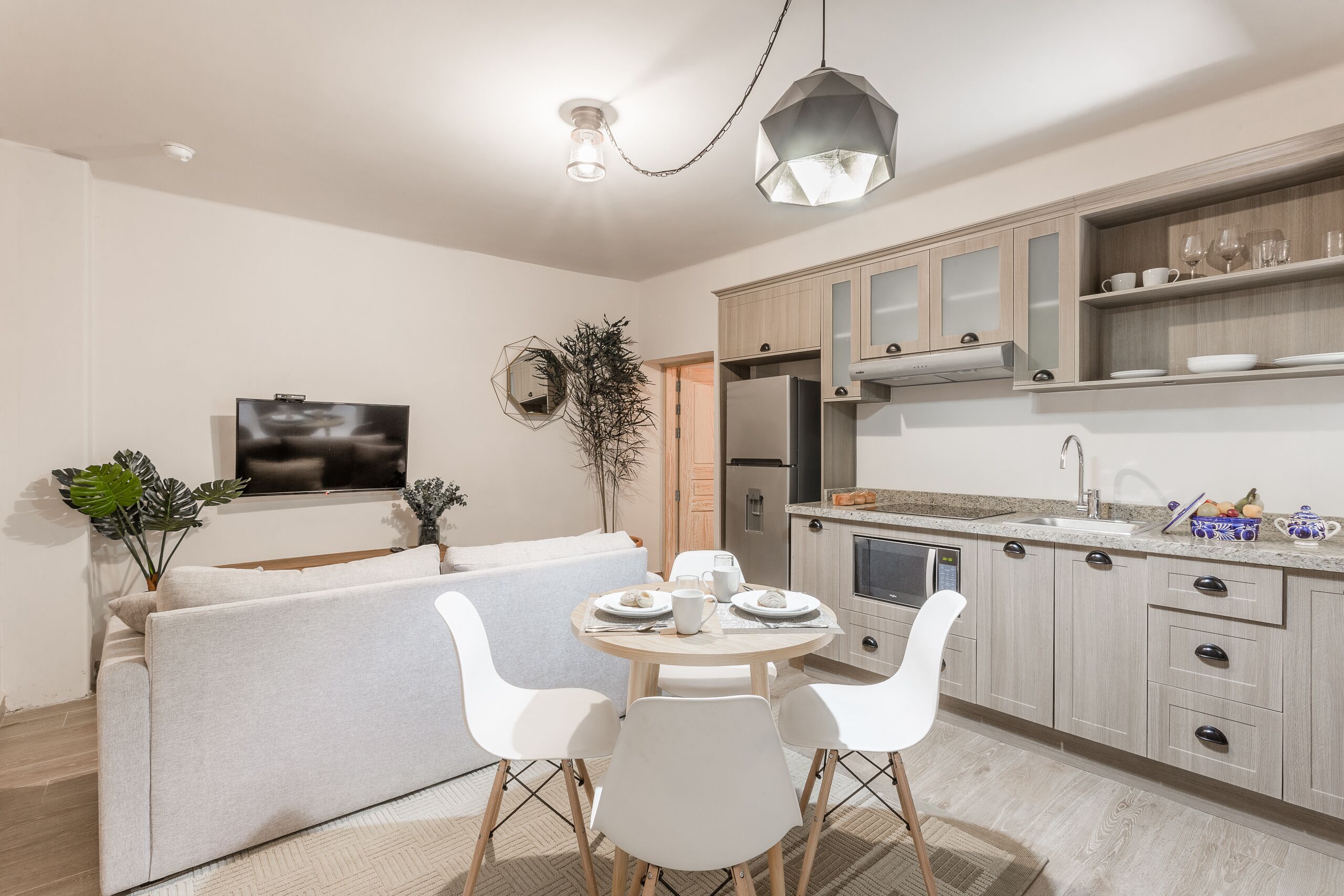 A modern kitchen with a dining area, a built-in oven, and a refrigerator.