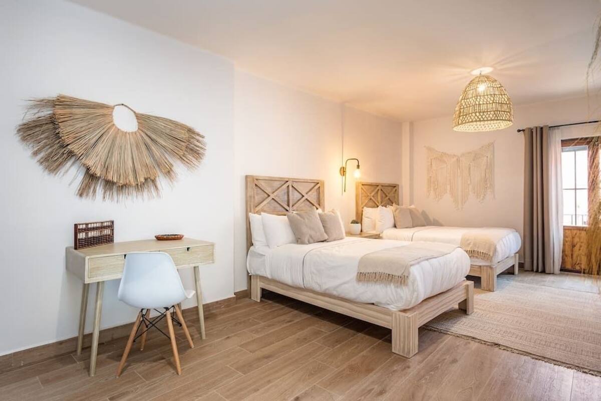 Een slaapkamer met twee bedden, een bureau en een stoel.