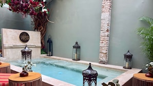 A serene outdoor area with a small pool, wicker furniture, and decorative lanterns. - Casa Pandurata Luxury Apartments in Centro, San Miguel de Allende (San Miguel de Allende)