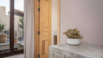 Una habitación con una puerta de madera, un armario blanco y una planta en maceta.