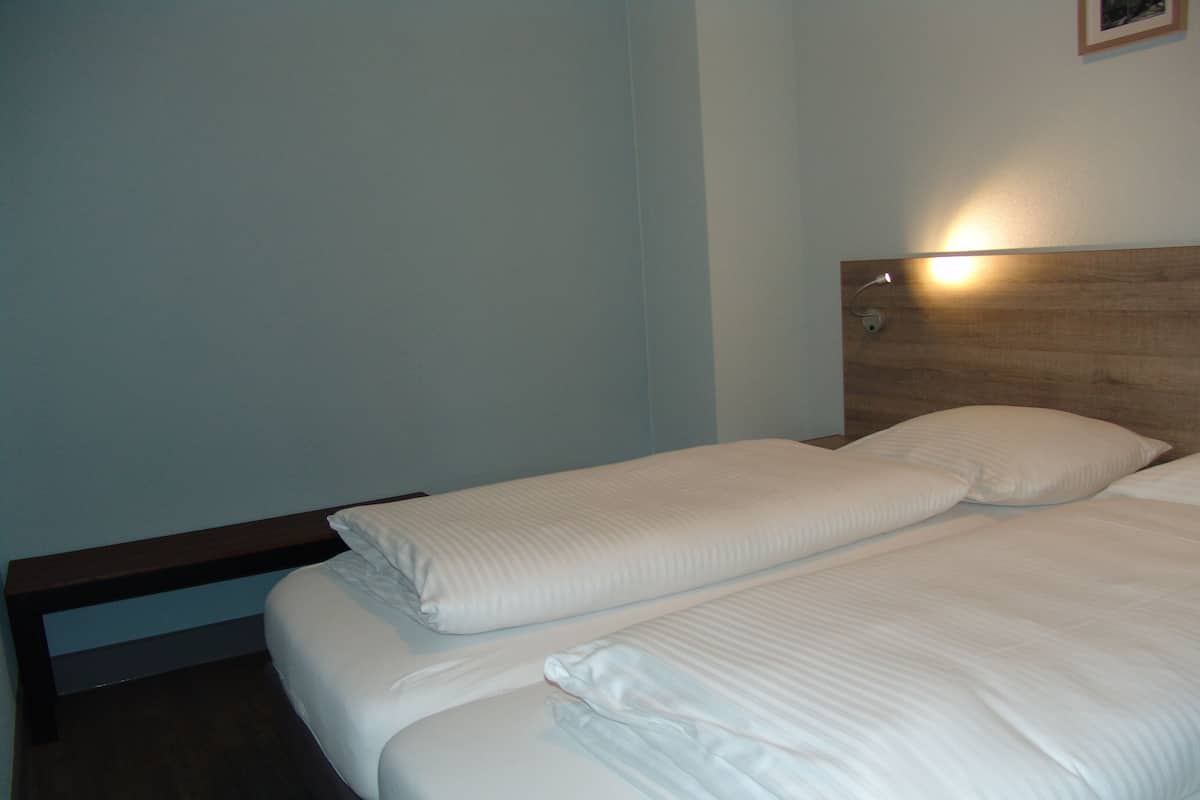 Un letto a due piazze con biancheria da letto bianca in una camera d'albergo.