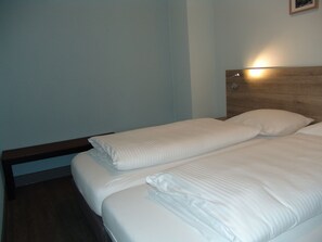 A twin bed with white bedding in a hotel room. - Brabander Alm (Biberwier)