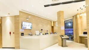 A hotel reception area with a reception desk, a digital screen, and a view of the outside. - City Comfort Inn Nanning Dongge Huacheng (Nanning)