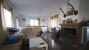 A living room with a fireplace, a sofa, a coffee table, and a television.