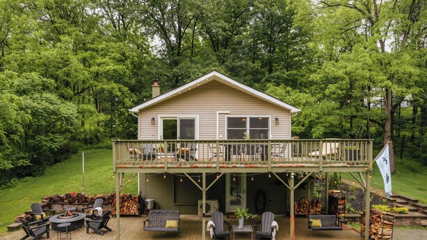 A two-story house with a balcony, outdoor seating area, and a fire pit. - 50-Acre Riverfront Farm – Dog Friendly & Sleeps 6 (Milanville)