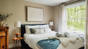 A neatly arranged bedroom with a large bed, bedside lamps, a framed picture on the wall, and a window with curtains. - 50-Acre Riverfront Farm – Dog Friendly & Sleeps 6 (Milanville)