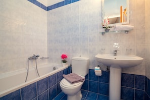 Een bad, een haardroger, handdoeken, toiletpapier