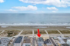 An aerial view of a coastal area with buildings, a beach, and the ocean.