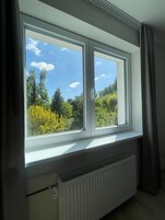 Una habitación con un ventanal grande con vistas a un área boscosa.