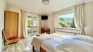A hotel room with a bed, a desk, a chair, and a TV. - AM BERG Hotel (Herzberg am Harz)