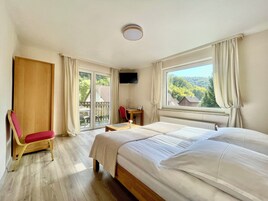 Una habitación de hotel con cama, escritorio, silla y televisión.