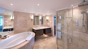 Ein modernes Badezimmer mit einer großen Badewanne, zwei Waschbecken, einer Duschkabine und einem großen Spiegel.