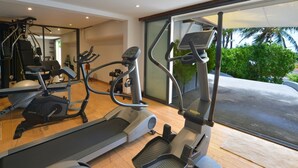 A gym with treadmills, ellipticals, and a rowing machine.