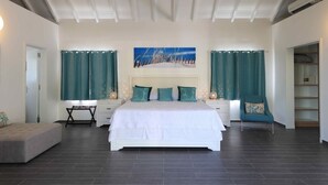 Ein modernes Schlafzimmer mit einem großen Bett, zwei Nachttischen, einem Sessel und einem Kleiderschrank.