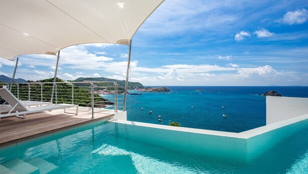 A poolside area with a view of the sea and a distant coastline. - Passage (1/2 Rooms) Luxury villa (Gustavia)