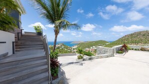 A staircase leading to a balcony overlooking a coastal town with a view of the sea and hills. - Lenalee (1/4 Rooms) Luxury villa (Gustavia)