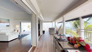 A spacious living area with a white sofa, a dining table set with flowers, and a view of the ocean. - Lenalee (1/4 Rooms) Luxury villa (Gustavia)
