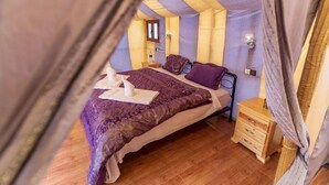 Um quarto aconchegante com cama, mesas de cabeceira e uma janela.