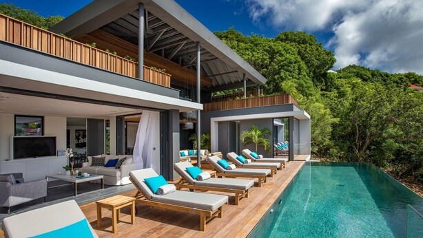 A modern villa with a pool, wooden deck, and lounge chairs. - Beautiful Sasha Luxury villa (Corossol)
