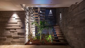 A modern interior with a staircase, stone walls, and indoor plants. - Beautiful Sasha Luxury villa (Corossol)