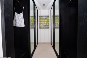 Un couloir doté de portes vitrées donnant sur un balcon avec vue sur la verdure.