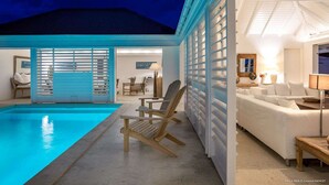 A modern pool area with a clear pool, wooden deck, and a cozy seating area with a sofa and chairs. - Supersky (2/3 Rooms) Luxury villa (St barts)