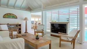 A spacious living area with a wooden coffee table, a TV, and comfortable seating. - Supersky Luxury villa (St barts)