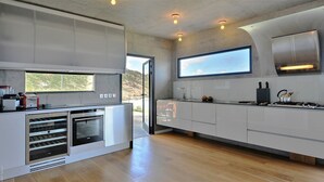 A modern kitchen with a built-in oven, a large window, and a view of the outdoors. - Eranos (1/2 Rooms) Luxury villa (St. Barts)