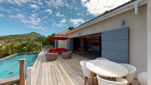 A wooden deck with a pool, outdoor seating, and a view of the landscape. - Nita (2/3 Rooms) Luxury villa (St. Barts)