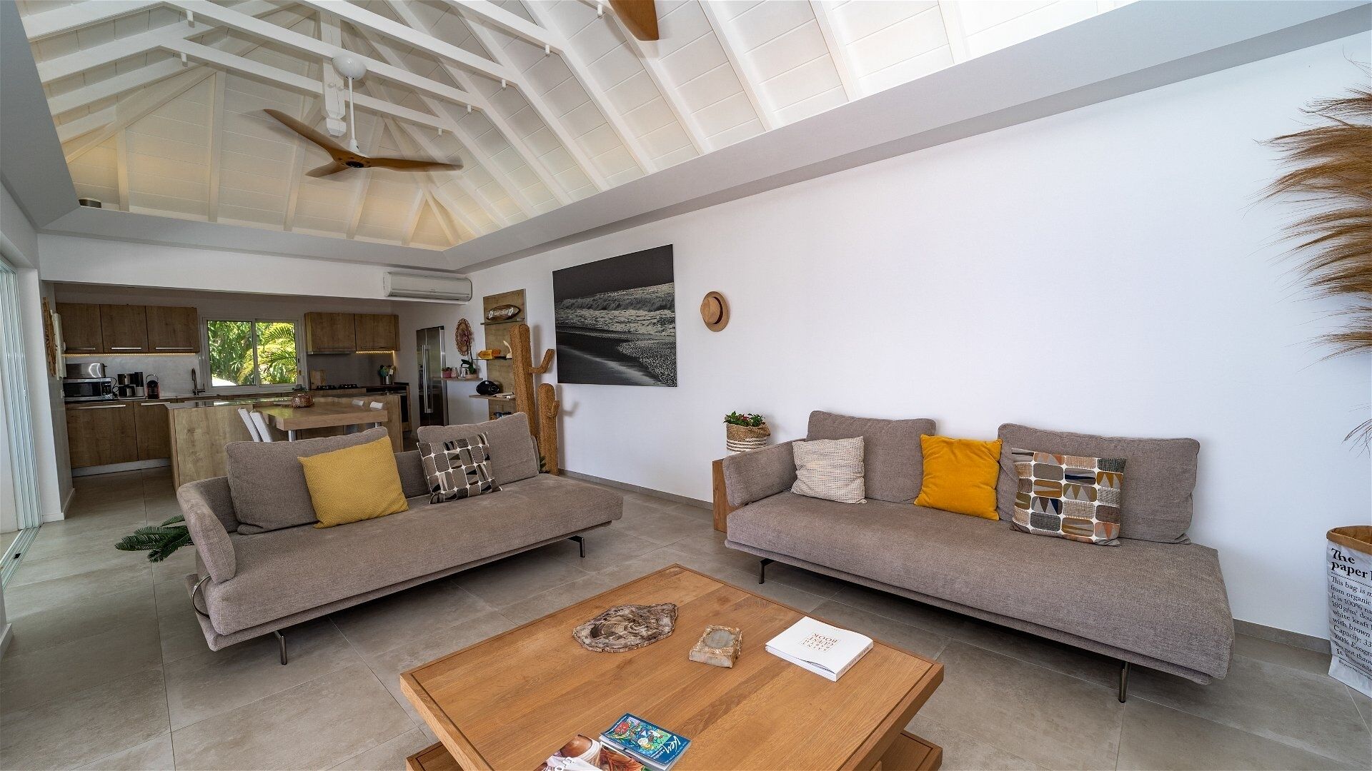 A modern living room with two sofas, a coffee table, and a kitchen in the background.