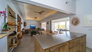 Eine moderne Küche mit einer großen Kochinsel, Holzschränken und einem Deckenventilator.
