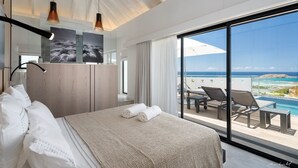 Ein modernes Hotelzimmer mit einem großen Bett, einem Balkon mit Meerblick und einem großen Fenster.
