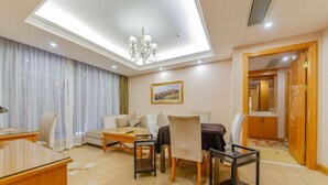 Een hotelkamer met een zithoek, een bank, een bureau en een kroonluchter.