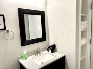 Une salle de bain équipée d’un lavabo, d’un miroir et d’un porte-serviettes.
