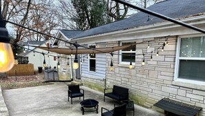 A patio with outdoor furniture and string lights.
