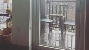 A room with a large sliding glass door leading to an outdoor balcony with two chairs and a table. - Enjoy Seattle with comfort and style! (Seattle)