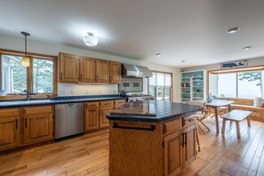 Kitchen features a central island with a countertop, surrounded by cabinets and a dishwasher.