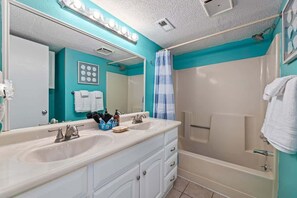 Bathtub, hair dryer, towels, shampoo
