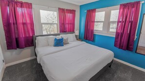 Una camera da letto con un letto, due finestre e tende.