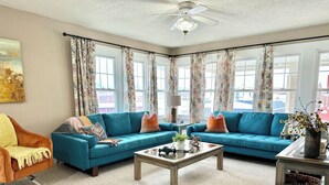A living room with two blue sofas, a coffee table, and a chair.