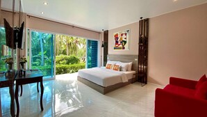 A modern bedroom with a large bed, a red armchair, and a TV on a stand.