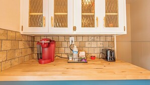A kitchen with white cabinets, a red coffee maker, a toaster, and a water dispenser on the counter. - Mountain Views Newly Renovated Home (Ogden)