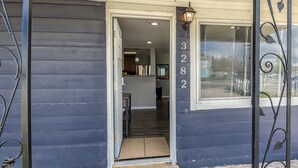 A house entrance with a dark blue exterior, a number '3282' on the wall, and a 'hello summer' mat at the door. - Dog Friendly and Family Sized Home (Denver)