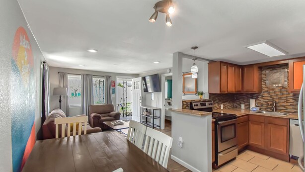 A modern kitchen with wooden cabinets, a built-in oven, and a sink. - Dog Friendly and Family Sized Home (Denver)