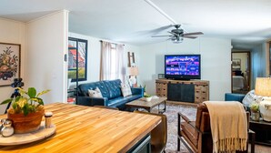 A living room with a television, sofa, coffee table, and a ceiling fan. -  Lake Rathbun Get Away  (Rathbun)
